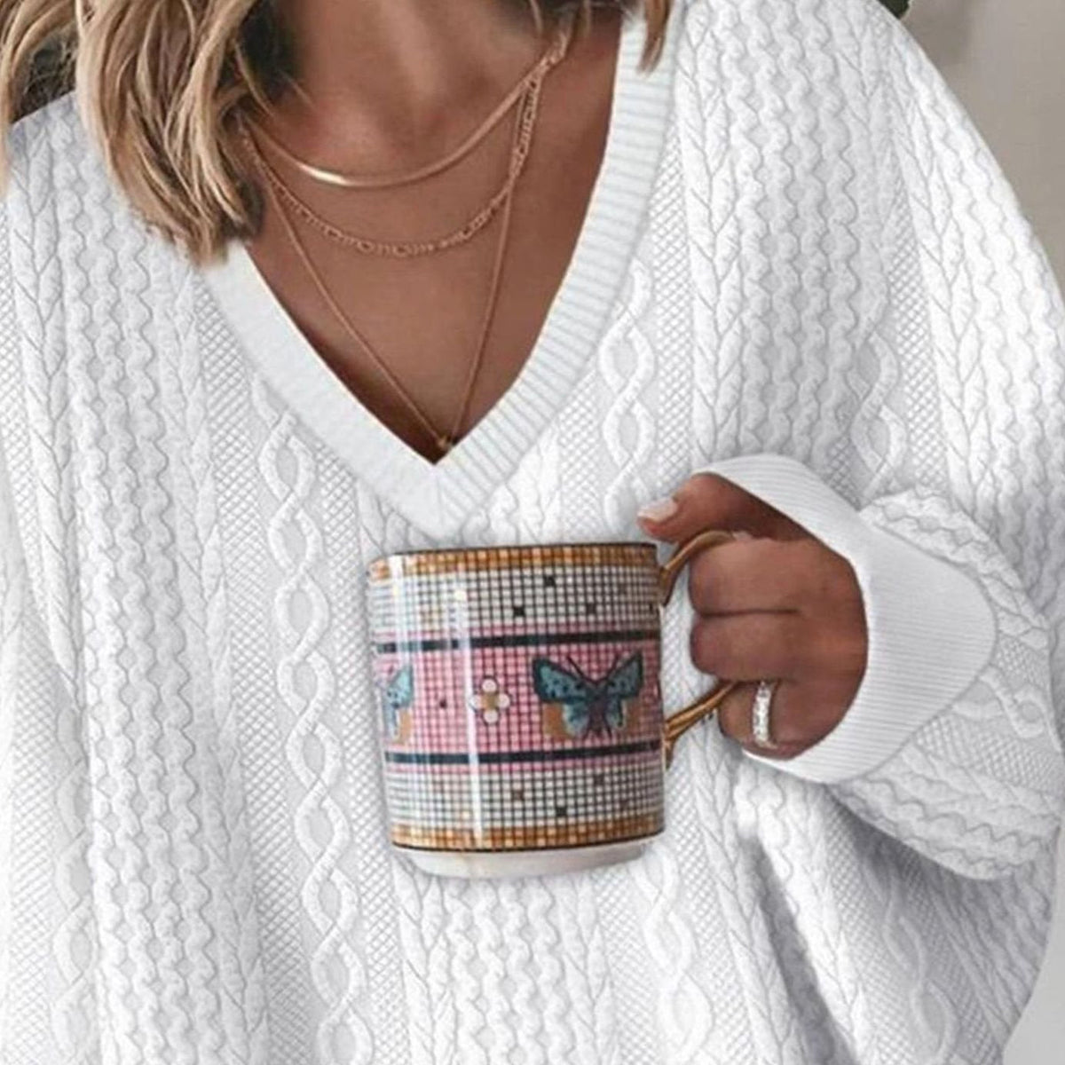 Women's oversized V-neck cable-knit long sleeve sweater, worn on model